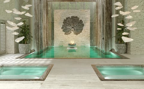 Unwind in serene spa pools beneath sculptural, calming stonework.