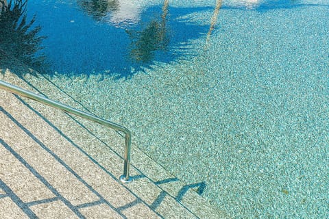 Dip your toes into sparkling water under dappled palm shadows.
