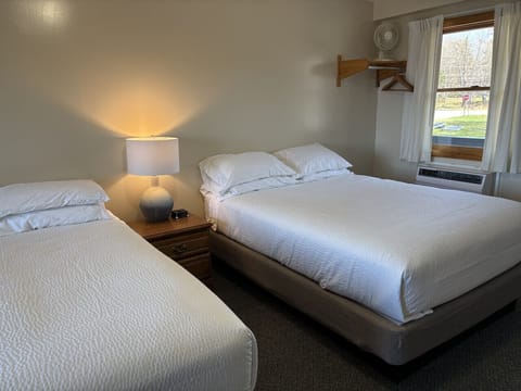 Comfortable bedroom featuring one queen bed and one twin bed with soft linens, natural light, and a relaxing atmosphere.