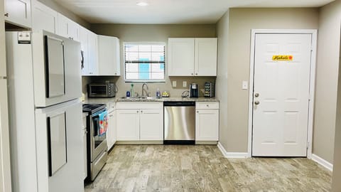 Fully furnished kitchen with cookware, stainless steel appliances, and more.
