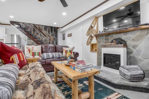 Relax in the inviting living room featuring a stone fireplace and rustic cabin charm.