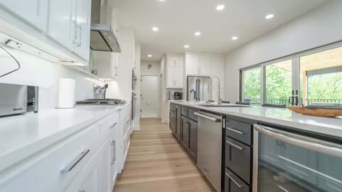 A symphony of sleek surfaces and natural light. Modernity redefined in this pristine kitchen. 