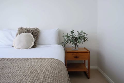 Find calm in this soothing bedroom, where natural elements and soft bedding promise a restful night.
