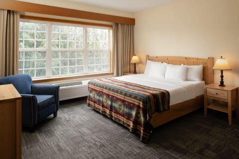 Unwind in a sunlit bedroom with cozy lodge-style comfort.