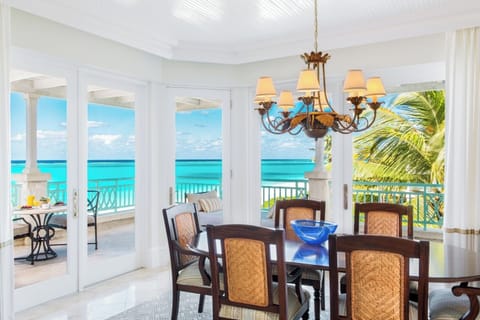 Gather for seaside meals with turquoise views through open doors.