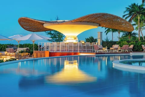Sip crafted cocktails beside the sculptural, lantern-lit pool bar.