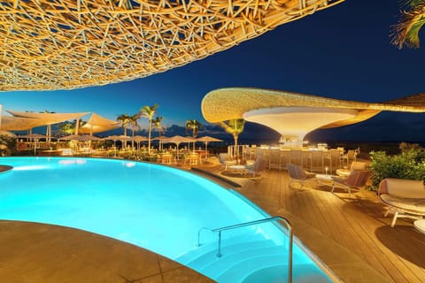 Unwind after sunset with glowing waters and chic poolside vibes.