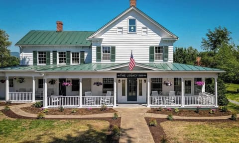Historic inn with a spacious porch featuring rocking chairs and hanging flower baskets