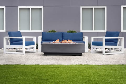 Lounge fireside on plush seating as flames gently flicker.