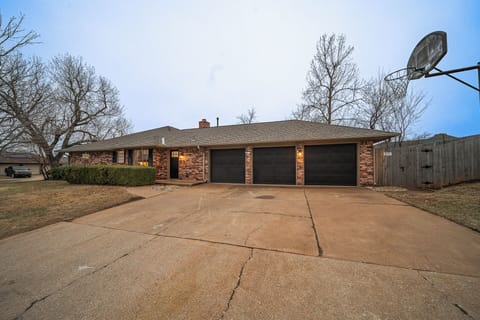 Expansive driveway and sleek black garage doors give this brick home a polished, welcoming look.