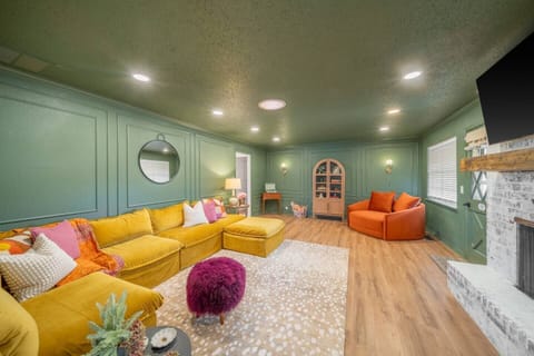 Stylish and cozy, this vibrant living room features bold colors, plush seating, and a warm, inviting atmosphere—perfect for relaxing or entertaining.