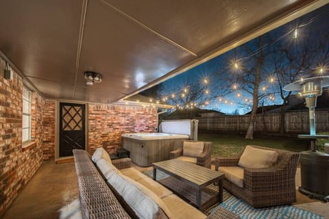 Transform your evenings in this private backyard retreat—complete with a bubbling hot tub, stylish wicker seating, twinkling string lights, and a covered patio. Perfect for entertaining or unwinding under the stars in a peaceful home.