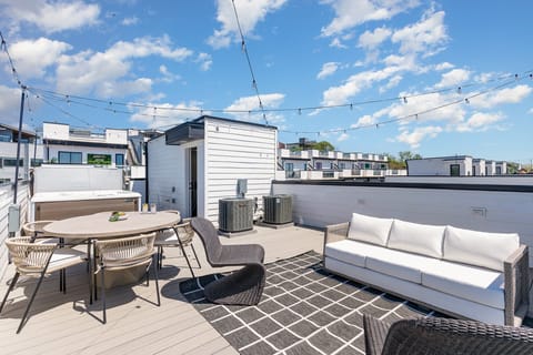 Rooftop deck with a hot tub, outdoor dining for 6, and cozy lounge seating—perfect for unwinding.