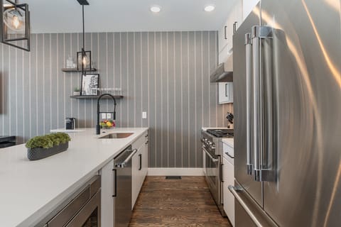 2nd Floor: Fully equipped kitchen with stainless steel appliances and a kitchen island with seating for 4 guests.