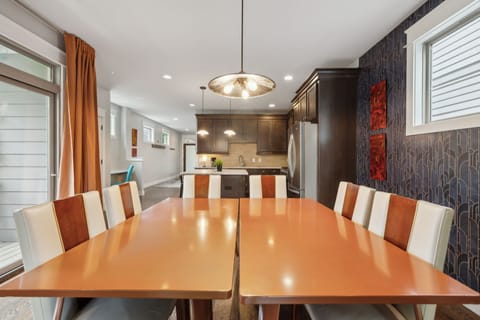 Dining Area: Host memorable meals at this stylish 8-seat dining table, framed by geometric wallpaper, warm wood floors, and striking modern artwork.