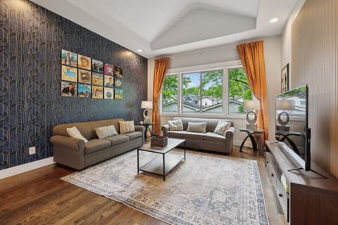 Living Room: Unwind on comfy couches, framed by striking Art Deco wallpaper and retro vinyl art. Style meets comfort in every corner.