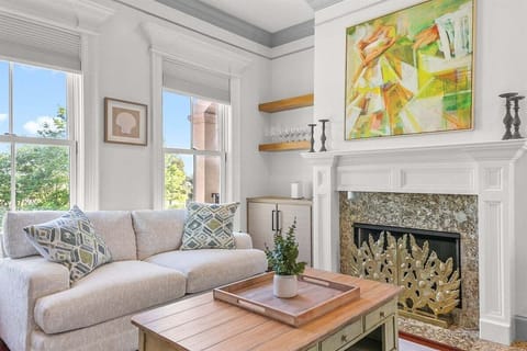 Sunlight pours through the large windows, filling this cozy living space with warmth and charm—perfect for morning coffee, afternoon lounging, or unwinding with a favorite show.
