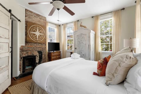This bedroom offers a warm and restful retreat, featuring soft linens, comfortable furnishings, and a serene atmosphere for a peaceful night’s sleep.