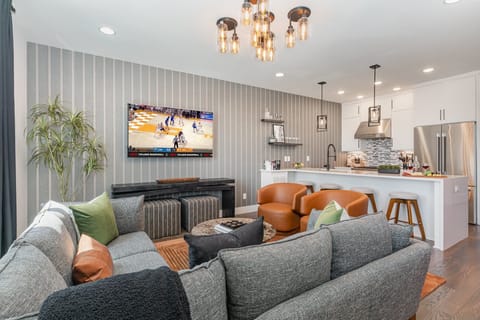 Unit 1 (2nd Floor): Open-floor living space featuring a Smart TV and designer furnishings.