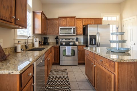 Spacious kitchen with modern appliances, perfect for preparing meals and gathering together. The laundry room is also in the kitchen for easy access. 