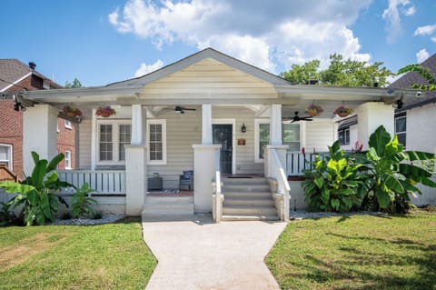 This charming property features a duplex each unit adorned with its own unique design and color palette. Nestled under a clear blue sky, these inviting houses include cozy porches and are part