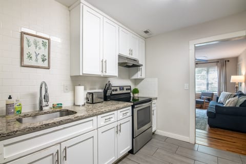 Modern kitchen with stainless steel appliances, white cabinetry, and granite countertops. Fully equipped for preparing your favorite meals.