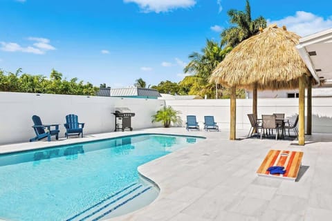 Stunning backyard with tiki and amazing pool featuring a built in bench for relaxing and crystal clear water!