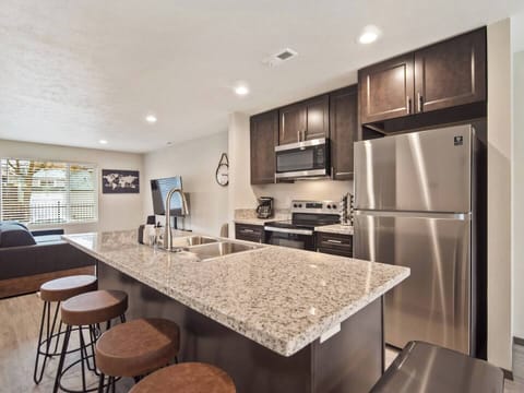 Full kitchen with sink in-island and bar seating. 