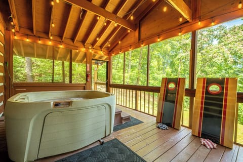 Soak in your private hot tub on the lovely porch while natural light and lush forest views surround you, with cornhole boards ready for friendly competition.