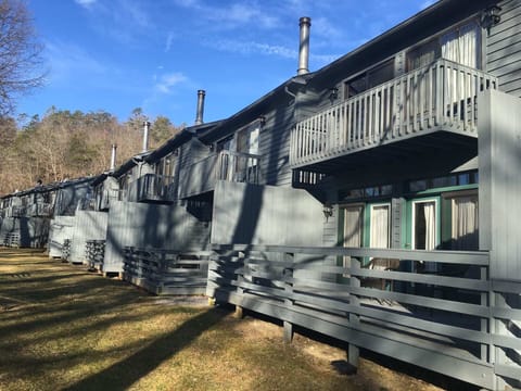 Exterior view of the tri-level townhome with a private balcony and ground-level patio.