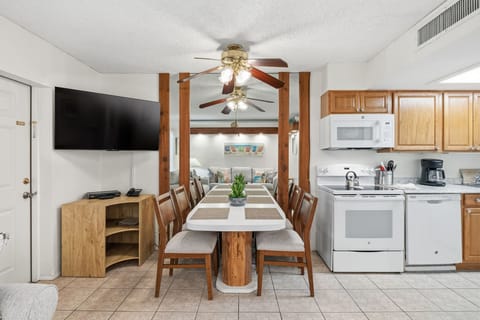 The dining area offers a spacious table with seating, positioned beside the kitchen and living space for easy gatherings.