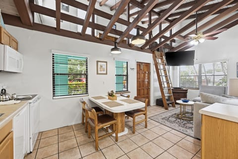 The open living and dining area features high wood-beamed ceilings, comfortable seating, and plenty of natural light.