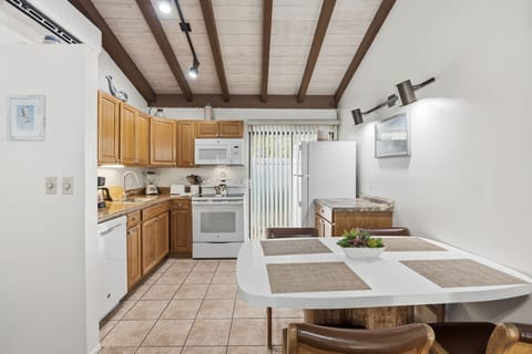 The dining area includes a round table with seating, conveniently located beside the fully equipped kitchen.