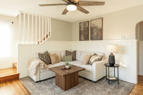 Step into this bright living space, where a cozy sleeper sectional invites relaxation. Stream your favorite shows on the smart TV, while large windows flood the room with natural light, creating a warm and welcoming ambiance. 