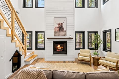 Bask in natural light by the fire, surrounded by modern charm and nature.