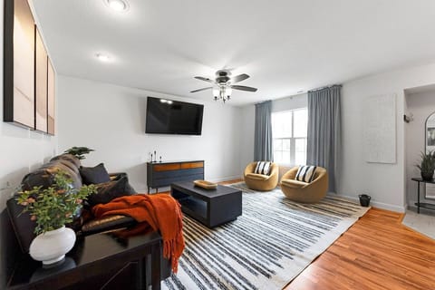 Stream family movies on the large Smart TV on the open-concept main floor, featuring fast WiFi, kid and pet-friendly spaces, and easy access to the secure, fully fenced backyard with an outdoor fire pit.