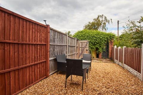 Fully fenced garden with outdoor seating.