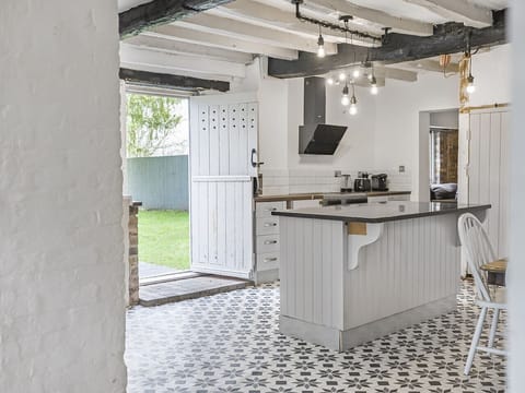 Equipped open plan kitchen with dining table opening up to the garden