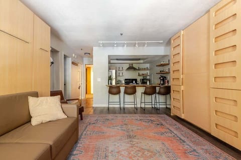 Beds fold up into sleek wall panels, instantly creating space for a cozy couch and an open, carpeted area—perfect for playing games on the floor or yoga. A smart, stylish way to maximize comfort and flexibility.