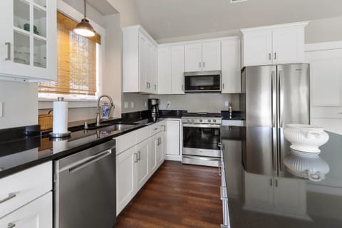 Fully equipped kitchen with gas stove, refrigerator, microwave, dishwasher, drip coffee maker