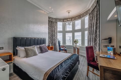 Wake up to sweeping sea views from this elegant bedroom.