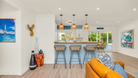 The fully stocked kitchen boasts a Sub-Zero fridge and acacia wood butcher block counters. A peninsula with seating provides the perfect spot for casual meals or morning coffee.