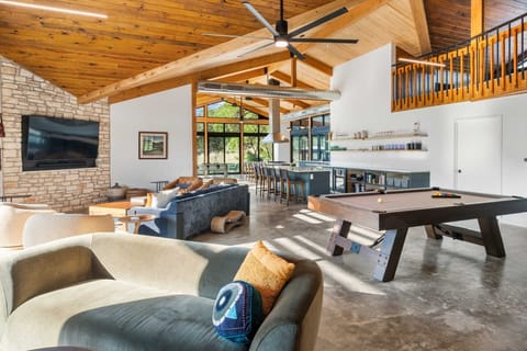 Spacious open-concept living with a pool table, bar, and cozy seating-perfect for entertaining or relaxing in style.