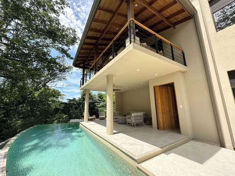 Walk up a set of stairs to the entrance of the home and a refreshing pool.
