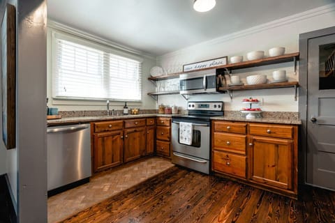 Kitchen with stove, oven, microwave, drop coffee maker, dishwasher and stocked with supplies.