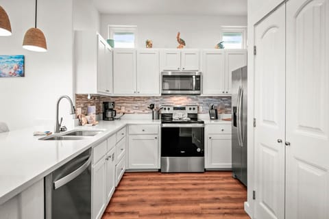 Cook up coastal cravings in this fully equipped modern kitchen with charming seaside touches.