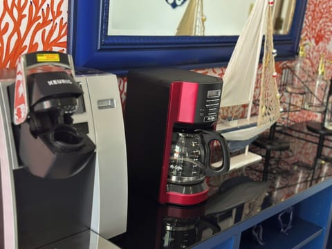 This convenient coffee station features both a Keurig single-serve brewer and a Mr. Coffee 12-cup programmable coffee maker, offering options for individual cups or brewing for a group. Situated on a stylish blue sideboard with nautical decor, this setup ensures your morning coffee routine is well catered for.