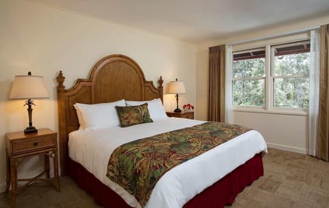 Unwind into crisp linens beneath a warm island-style headboard.