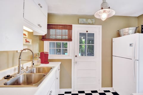 Bright Kitchen With Backyard Access - The updated kitchen features backyard access, a double sink, and vintage charm—ideal for quick meals between beach runs on St. Simons Island.