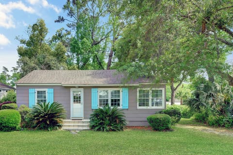 Front Exterior With Coastal Shutters - 204 Ashantilly Avenue makes a bold first impression with bright blue shutters, a wide front yard, and classic St. Simons Island charm—just minutes from the beach.